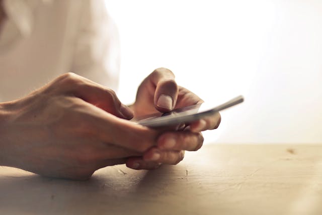pexels-adrienn-638530-1458283 - GeoPlugin - Resources A person holding a mobile device with both hands.