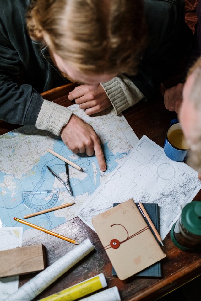 pexels-cottonbro-5302811 - GeoPlugin - Resources A person pointing to a location on a map.