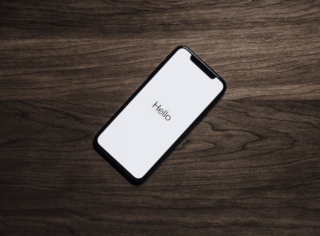 pexels-lastly-699122 - GeoPlugin - Resources A mobile phone on a table with the word “Hello” showing.