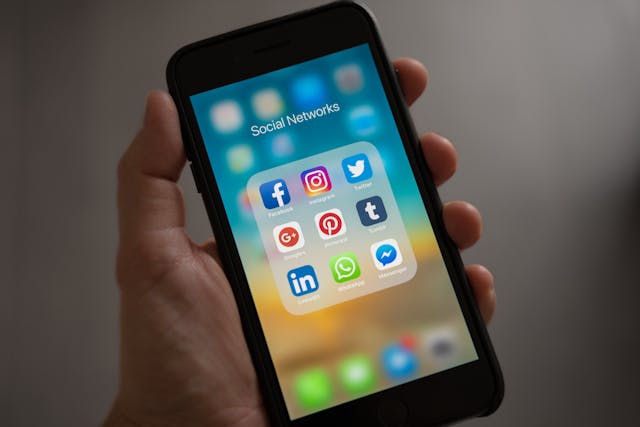 pexels-tracy-le-blanc-67789-607812 1 - GeoPlugin - Resources A person holding a phone that’s showing social media apps.