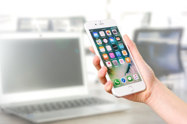 pexels-asphotograpy-887751 - GeoPlugin - Resources A person holding a mobile device that’s showing apps.