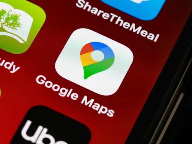 pexels-brettjordan-5444631 - GeoPlugin - Resources The Google Maps app icon on a smartphone screen with a red background.