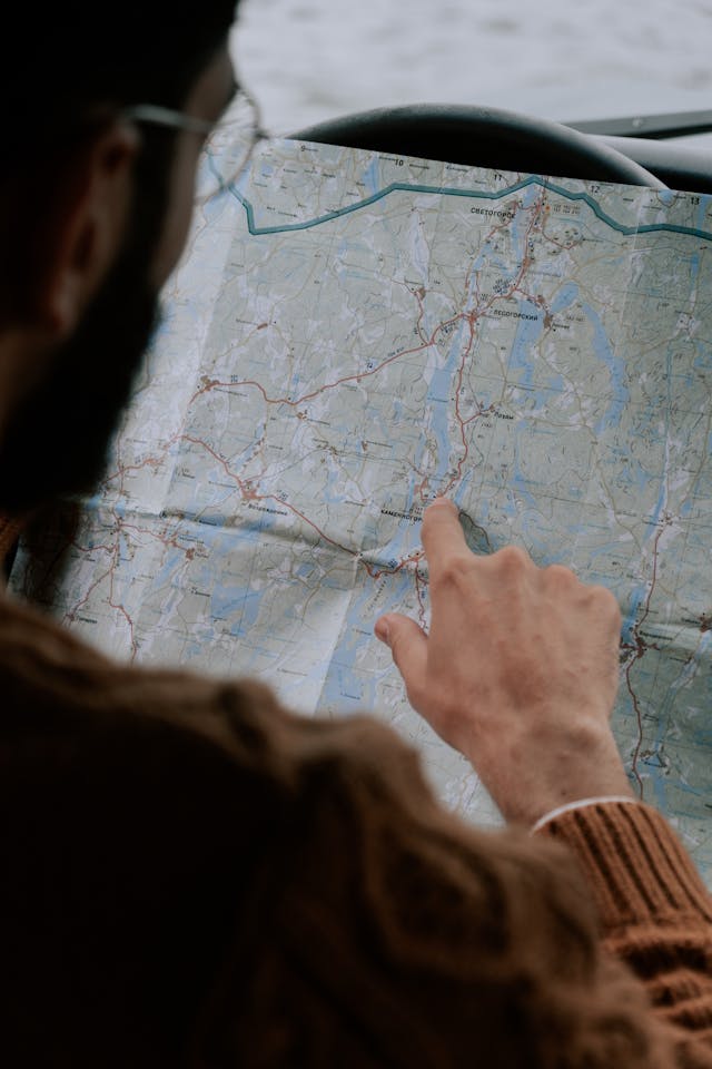 pexels-cottonbro-5967048 - GeoPlugin - Resources A man pointing to a location on a map.