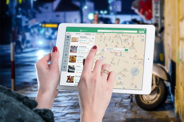 pexels-pixabay-38271 - GeoPlugin - Resources Image showing a woman holding an iPad containing location information of different territories.