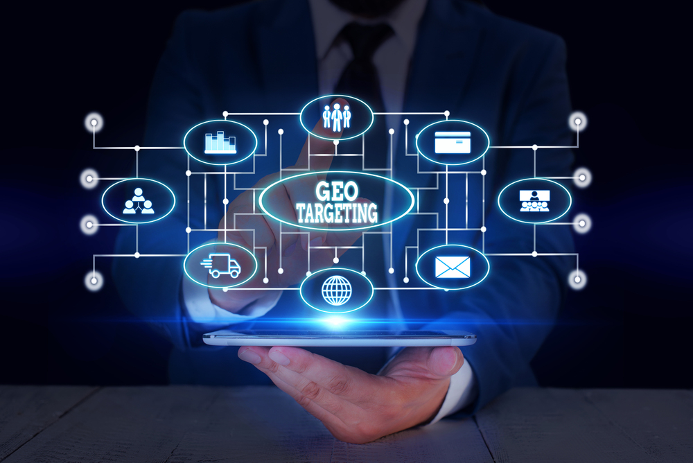 Text sign showing Geo Targeting Conceptual photo Digital Ads Views IP Address Adwords Campaigns Location Male human wear formal work suit presenting presentation using smart device - GeoPlugin - Resources Image showing industries that benefit from geo targeting.